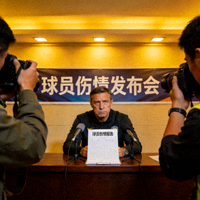 球员伤情发布会现场画面，教练面色严肃